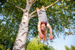 © Dmitry Naumov - Happy girl hanging from a tree in a summer park