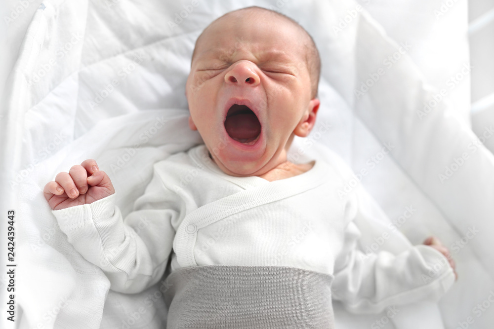 Płaczący noworodek. Pierwsze dni na świecie, noworodek śpi w łóżeczku. - obrazy, fototapety, plakaty 