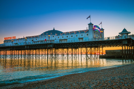 Wall Mural - Brighton Pier beach with sunset golden hour at Sussex England, UK. Brighton Marine Palace and Pier popular place for visitor.