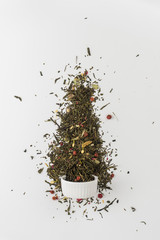 Dry leaves of Sencha green flower tea with cowberry leaf, red currant, Jasmine, rose petals, honey granules, forest berry aroma on white background