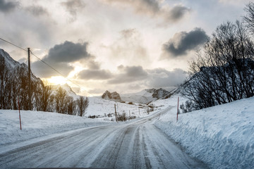 Wall Mural - Dirty snow road with sunlight on mountains