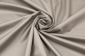 gray sateen fabric with steel gloss is laid by folds on diagonal to the center in the form of a spir