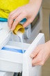 © anetlanda - Person pouring fabric softener into washing machine