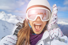   Woman Skier Standing At Snow Looking At Camera. Winter Montain Background