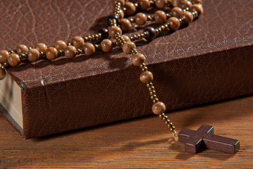 Canvas Print - Book with rosary on the wooden table.