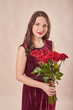 © Aleksandr - young attractive girl with red roses on a beige background on Valentine's Day February 14