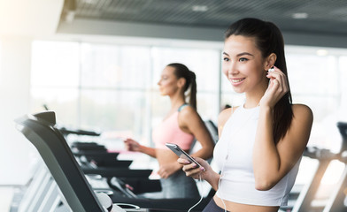 Girl training in gym and listening to music