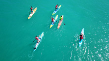 Aerial Photo Of Colourful Sport Canoes In Competition As Shot From Above In Turquoise Clear Waters