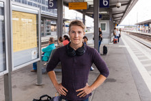 Young Man With Hands On Hips, Standing At Rail Station In Aschaffenburg, Germany