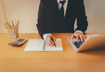 Working process startup. Businessman working at the wood table with new finance project. Modern notebook on table. Pen holding hand