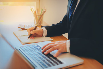 Working process startup. Businessman working at the wood table with new finance project. Modern notebook on table. Pen holding hand