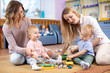 © Oksana Kuzmina - Group of babies playing with colorful educational toys and mothers in nursery room
