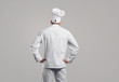 Chef cook in white uniform standing back view .
