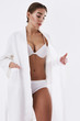 © Yakobchuk Olena - Beautiful young lady in bathrobe and lingerie standing on white background