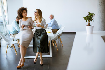 Two young businesswomen with a tablet in the office