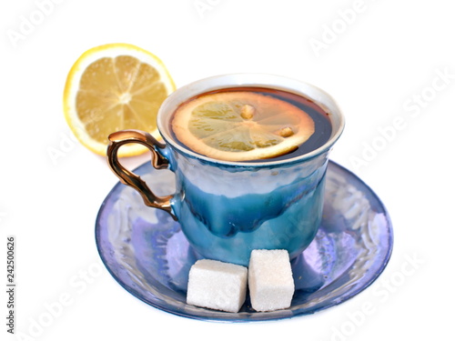 Fotografie, Obraz Vintage elegant stylish graceful beautiful porcelain cup with golden handle and two pieces of sweet sugar on dish of morning tea with lemon on white background with half lemon