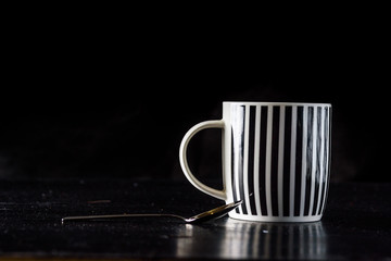 Coffee mug on a black wooden background.