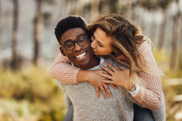 Interracial couple piggybacking outdoors