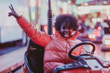 Excited Black Woman Riding Car In Amusement Park