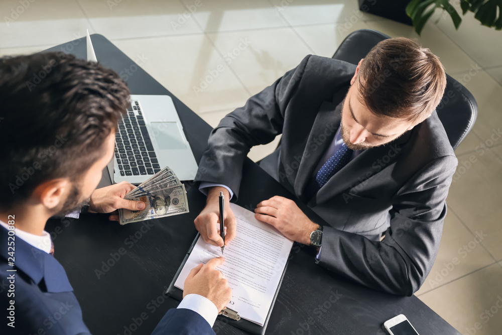 Man giving bribe to businessman in office. Concept of corruption