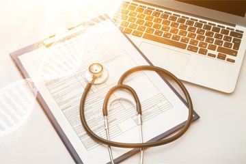 Modern laptop and stethoscope on wooden background