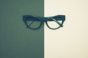 Top view flat lay, modern blue eye glasses on pastel paper background