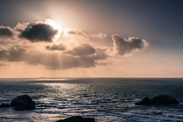 Wall Mural - Sun bursting from behind clouds, Lands End, San Francisco, California