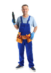 Wall Mural - Electrician with drill wearing uniform on white background