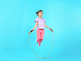 Sticker - Full length portrait of girl jumping rope on color background