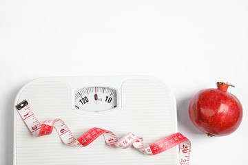 Poster - Composition with scales, tape measure and pomegranate on white background, top view