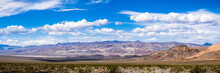 Panoramic Landscape Of Colorful Mountains And Volcanic Areas In Death Valley National Park; Blue Sky And White Clouds In The Background; California