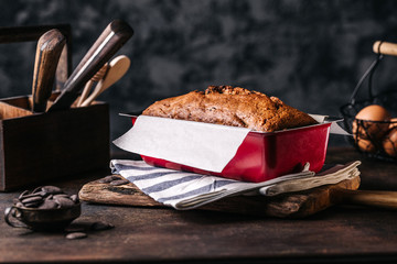 Poster - Rustic arrangement of baked bread loaf in metal form on wooden table with utensil around