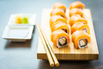 Poster - Salmon fish meat sushi roll maki on wood plate