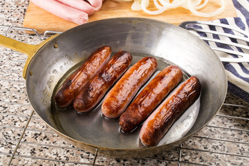 Wall Mural - home made british sausages in a brass pan