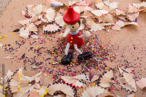 Pinocchio sitting amid pencil shavings
