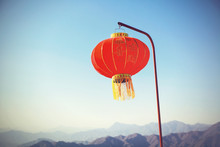 Chinese New Year Lantern Hanging On The Pole Over Blue Sky And Mountain