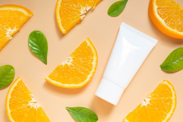 Canvas Print - Natural vitamin c skincare products w/ fresh juicy orange fruit slice and green leaf on orange background. Cosmetic beauty product branding mock-up for moisturizing cream, lotion, foam or shampoo.