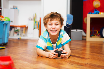 a boy playing with radio-controlled car at home.