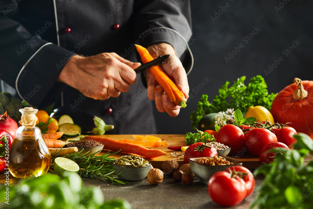 Chef slicing fresh carrots for a salad - obrazy, fototapety, plakaty 