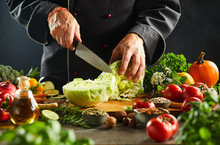 Chef Chopping A Fresh Cabbage With A Kitchen Knife