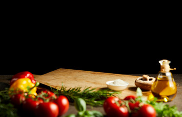 Fresh cooking ingredients around a wooden board