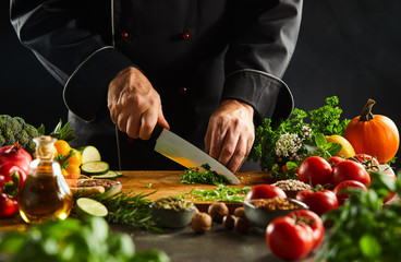 Chef dicing fresh herbs with a kitchen knife