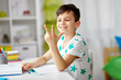 © Syda Productions - education, childhood and school concept - happy student boy counting using fingers at home