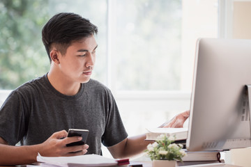 Wall Mural - attractive asian businessman / student young man sitting working busy for seaching information data 