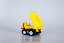 Selective Focused On Yellow Toy Dump Truck Made From Plastic. Isolated On White Background. 