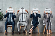 © LIGHTFIELD STUDIOS - multiethnic businesspeople sitting and holding cards with 'director' words and question mark in front of faces in waiting hall