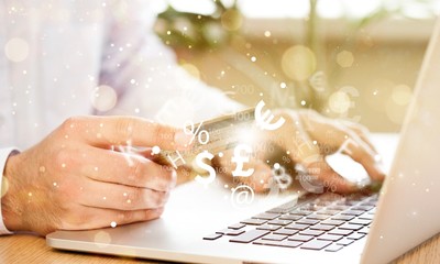 Poster - Closeup of a Man Typing on a Laptop and Holding a Credit Card