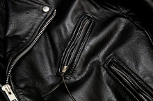 Detail Of Classic Old Black Leather Police Style Motorcycle Jacket Focusing On Zippers And Pockets.