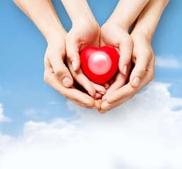 Poster - Man and woman holding red heart in hands isolated on white