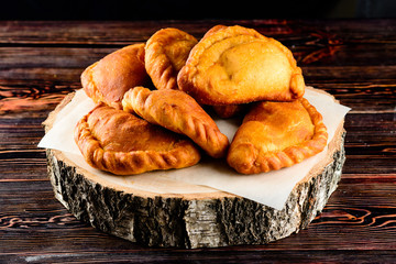 Sticker - Fried homemade pies on a wooden background in rustic style